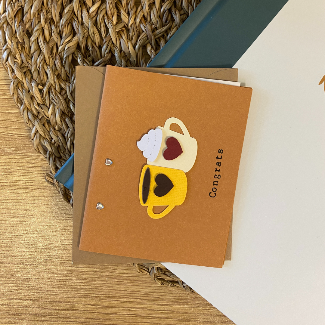 Carte de souhaits en papier kraft représentant deux tasses à café avec des coeurs.